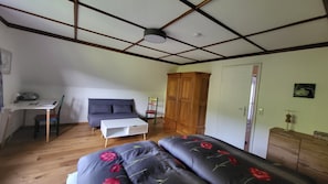 Une pièce comprenant un lit, un bureau, une chaise, une armoire et une porte.