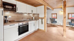 A modern kitchen with white cabinets, a Bosch microwave, and a wooden ceiling. - Apartment 'Hochwald' with Mountain View and Wi-Fi (Bertsdorf-Hörnitz)