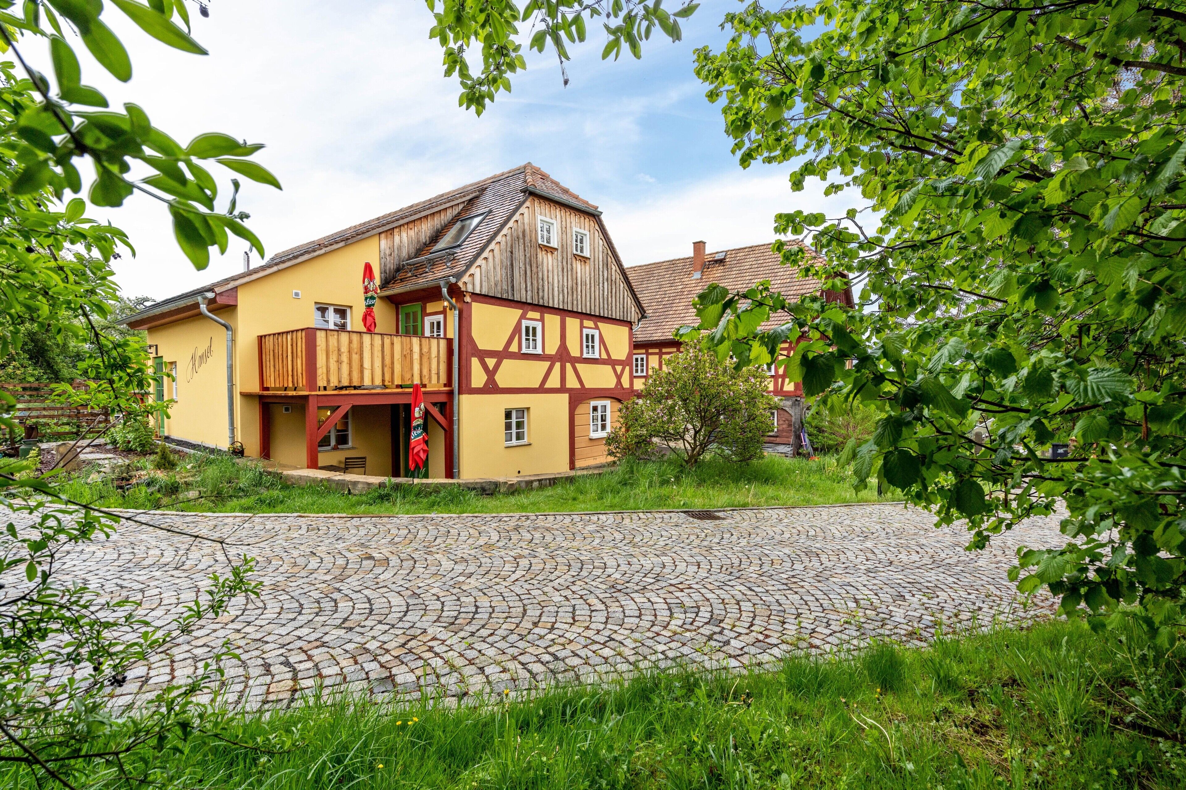 Ein traditionelles Fachwerkhäus mit einem Kopfsteinpflasterhof.