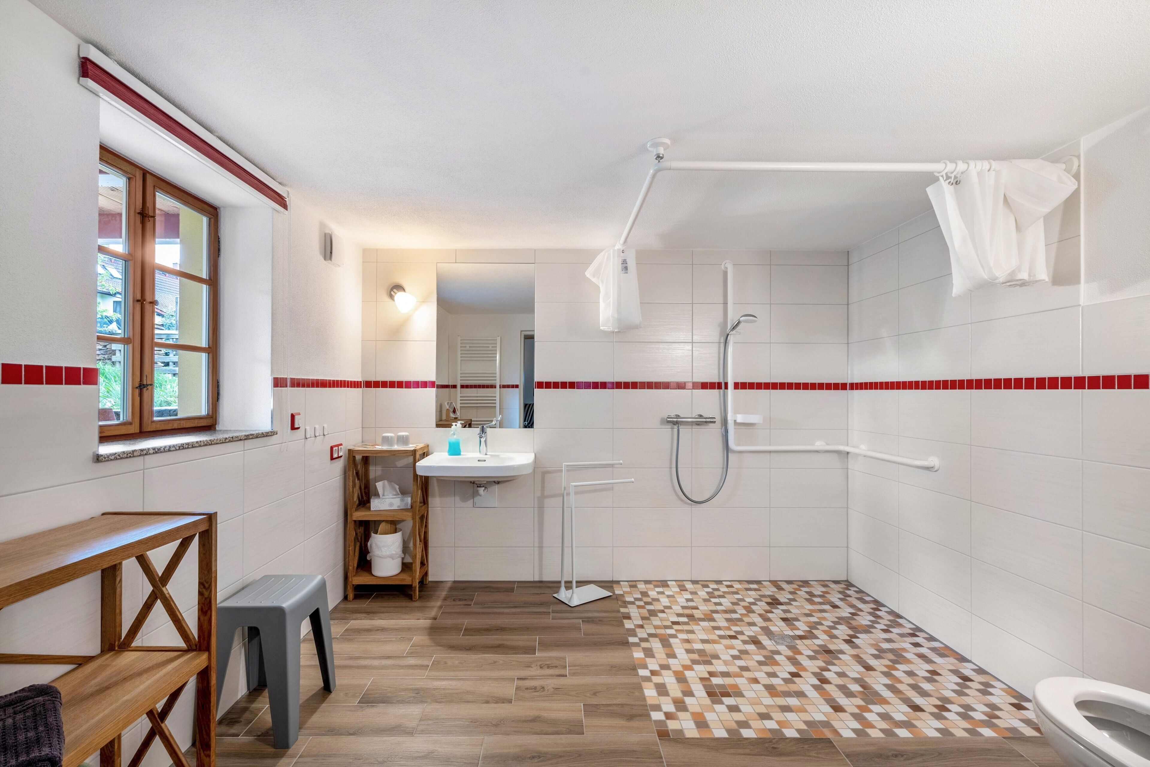Baño con ducha, inodoro, lavabo y ventana.