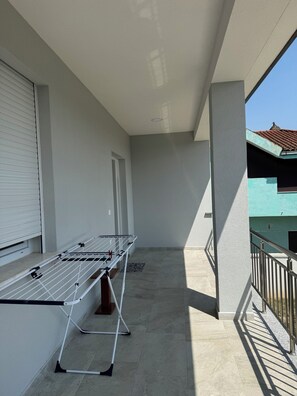 A balcony with a drying rack, a window with blinds, and a tiled floor. - Charming 3-bedroom Villa in lovely Shkodër with AC (Shkodër)