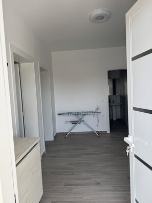 A hallway with a wooden floor, a ceiling light, and a door on the right. - Charming 3-bedroom Villa in lovely Shkodër with AC (Shkodër)
