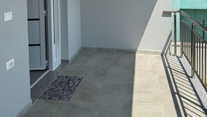 A balcony with a metal railing, a tiled floor, and a door leading to an interior space. - Charming 3-bedroom Villa in lovely Shkodër with AC (Shkodër)