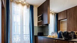 Une cuisine moderne avec des meubles en bois, un four à micro-ondes et une machine à café.
