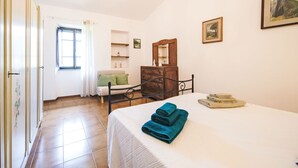 A bedroom with a bed, a dresser, a chair, a window, and a chandelier. - Casa Brezza del Gabberi by Interhome (Camaiore)