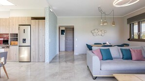 Ein modernes Wohnzimmer mit grauem Sofa, einem Holztisch und einem Essbereich mit Tisch und Stühlen.