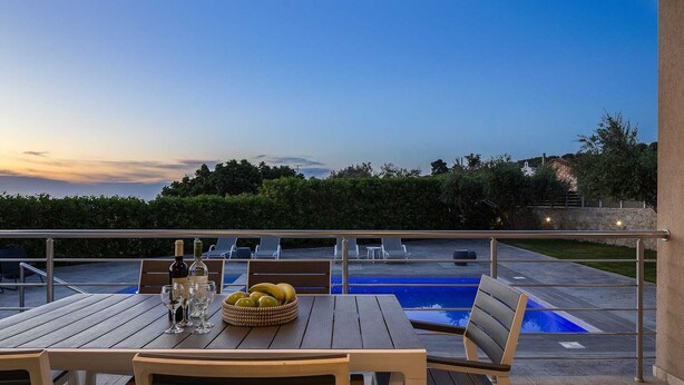 Eine Terrasse mit Esstisch, einem Pool und Blick auf die Landschaft.