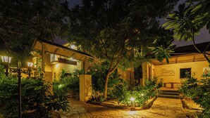 A courtyard with stone pathways, a wooden bench, and a small illuminated plant. - Tehla Bagh (Talab)