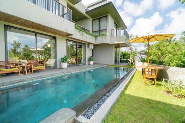 A modern house with a swimming pool, outdoor furniture, and a garden. - Renjana Boutique Villas Ubud by Premier HospitalityAsia (Ubud)