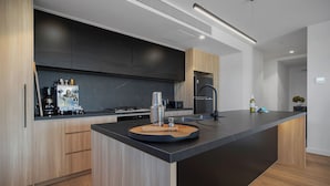Una cocina moderna con una isla central, electrodomésticos integrados y un diseño elegante.