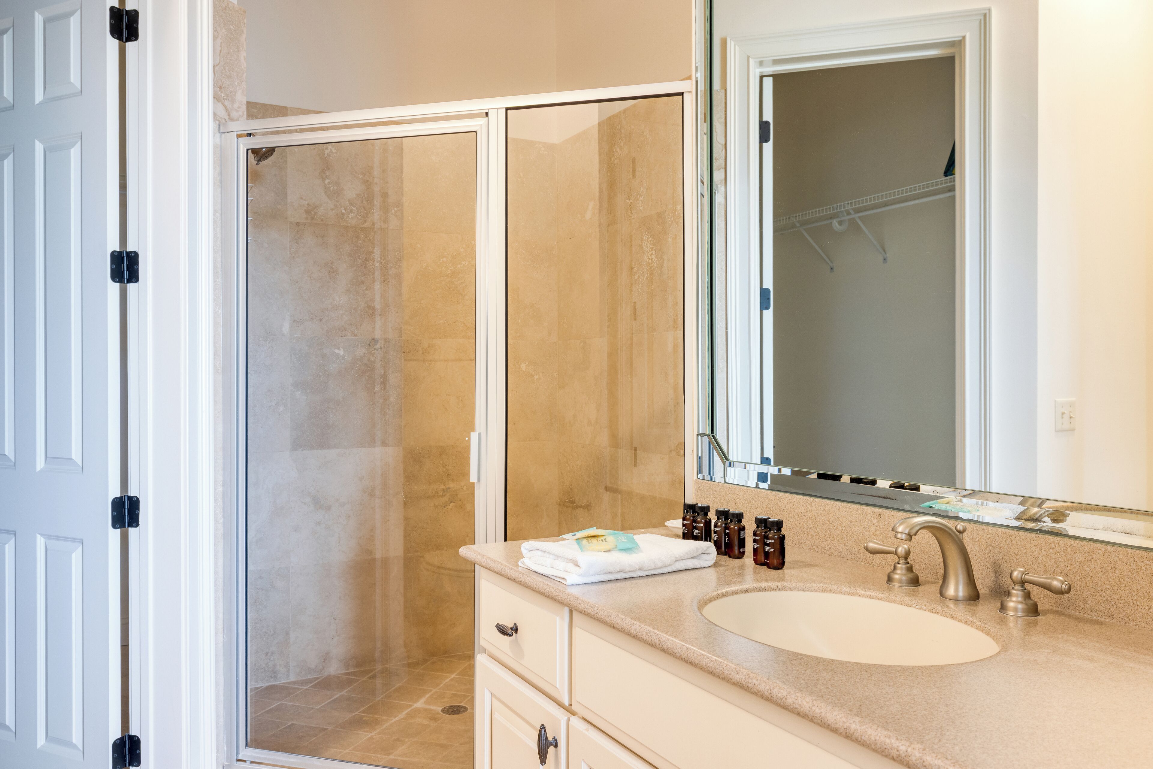 A bathroom with a shower, sink, and mirror.