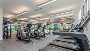 Un gimnasio moderno con cintas de correr, elípticas y equipo de levantamiento de pesas.