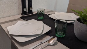 A neatly set dining table with plates, cutlery, glasses, and a potted plant. - Apartment 'An Der Quell' with Private Terrace, Private Garden and Wi-Fi (Blankenheim)