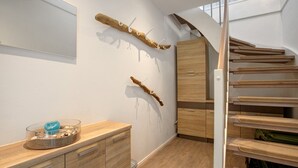 Ein modernes Interieur mit Holzboden, einer Treppe und einem an der Wand befestigten Kleiderhaken.