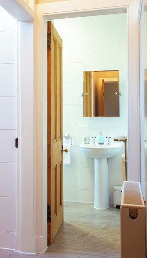 Regadera, secadora de cabello, toallas, papel de baño 