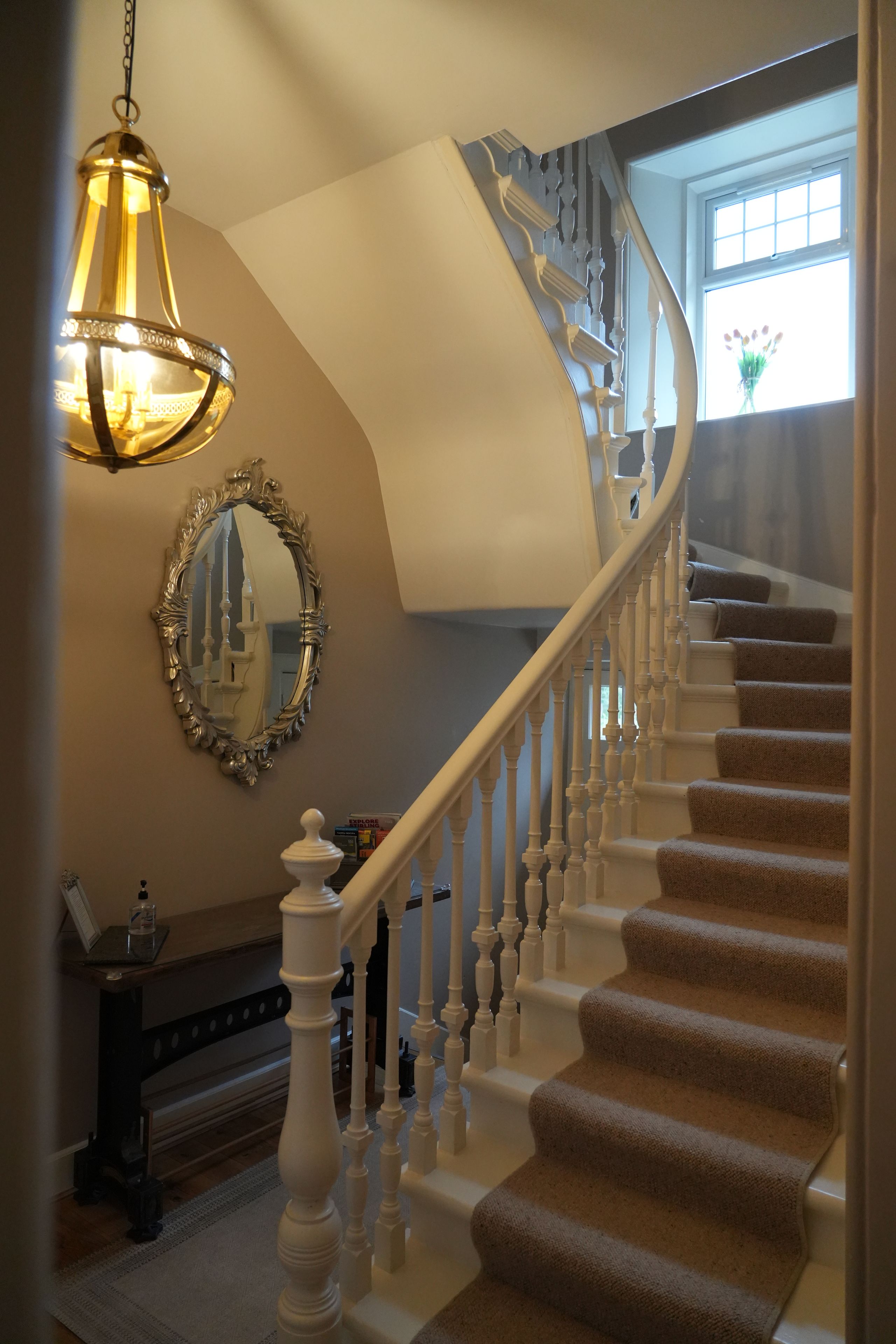 A grand staircase with ornate railings and a chandelier.