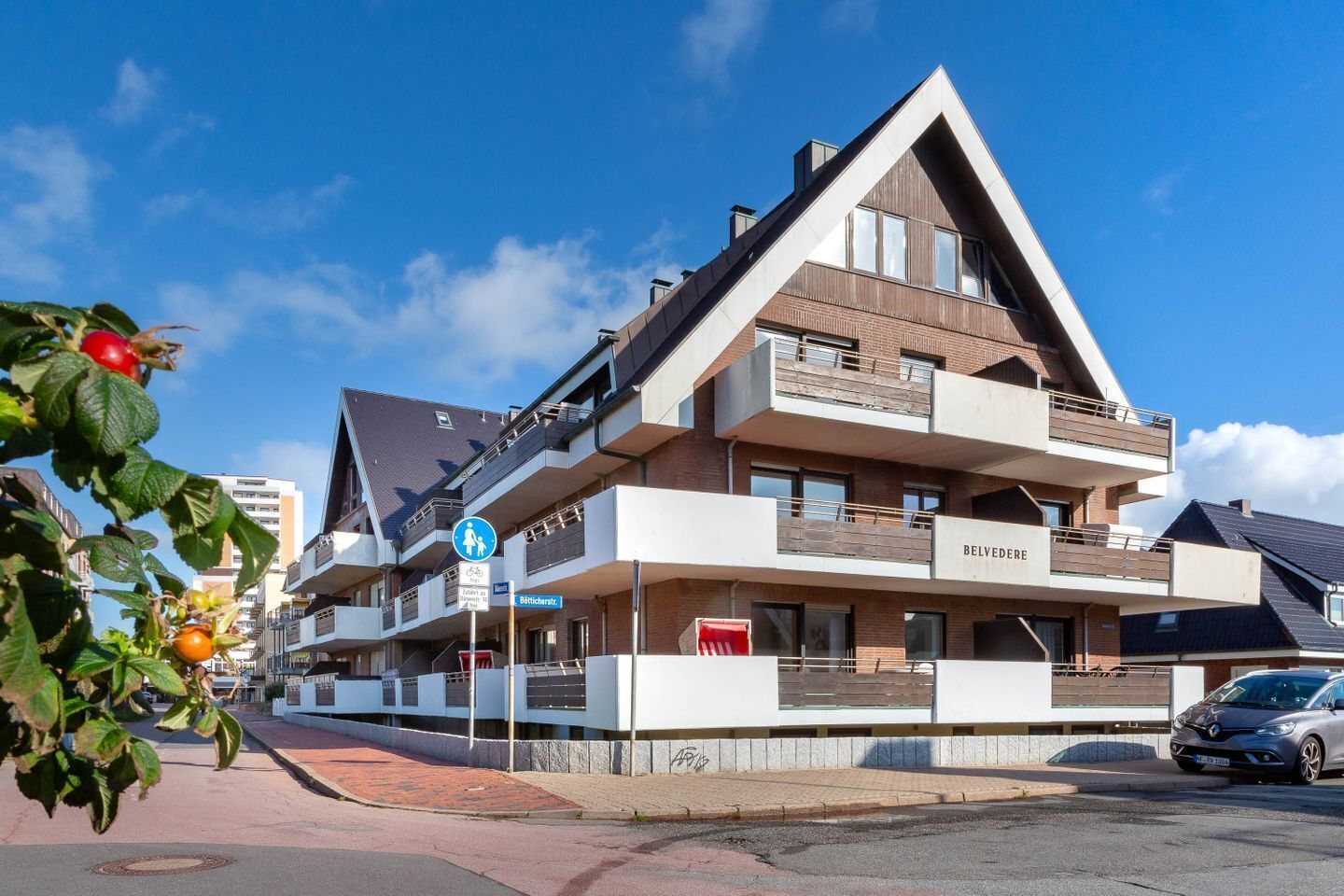 Ein mehrstöckiges Hotel mit modernem architektonischen Design, mit Balkonen und einem markanten Eingang.