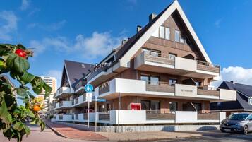 Ein mehrstöckiges Hotel mit modernem architektonischen Design, mit Balkonen und einem markanten Eingang.