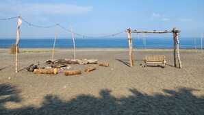 A beach with a wooden structure, possibly a gazebo, and a bench. - Kulibangbang Beach Resort (Bacnotan)
