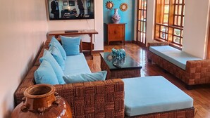 A cozy living room with a sofa, a coffee table, and a large vase. - Kulibangbang Beach Resort (Bacnotan)