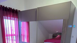 A bedroom with a bed, a large mirror, and a sliding wardrobe. - LivingMe Cozy 3 rooms to relax in (Korntal-Münchingen)