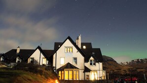 A row of houses with a clear night sky and visible stars. - Scott Cottage - Luxury in the heart of Loch Lomond & The Trossachs (Stronachlachar)