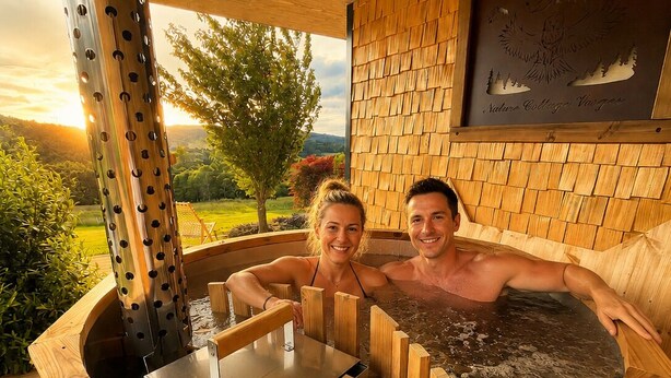 Un bain à remous aux parois en bois et à la structure métallique, entouré d’une terrasse en bois.