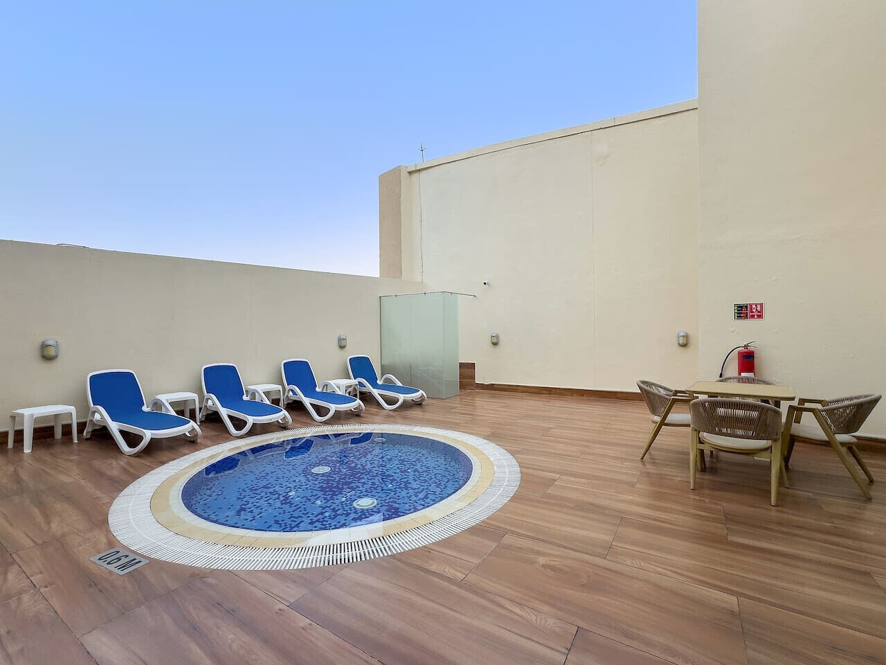 Un espace piscine aménagé sur le toit, avec des chaises longues et une table.