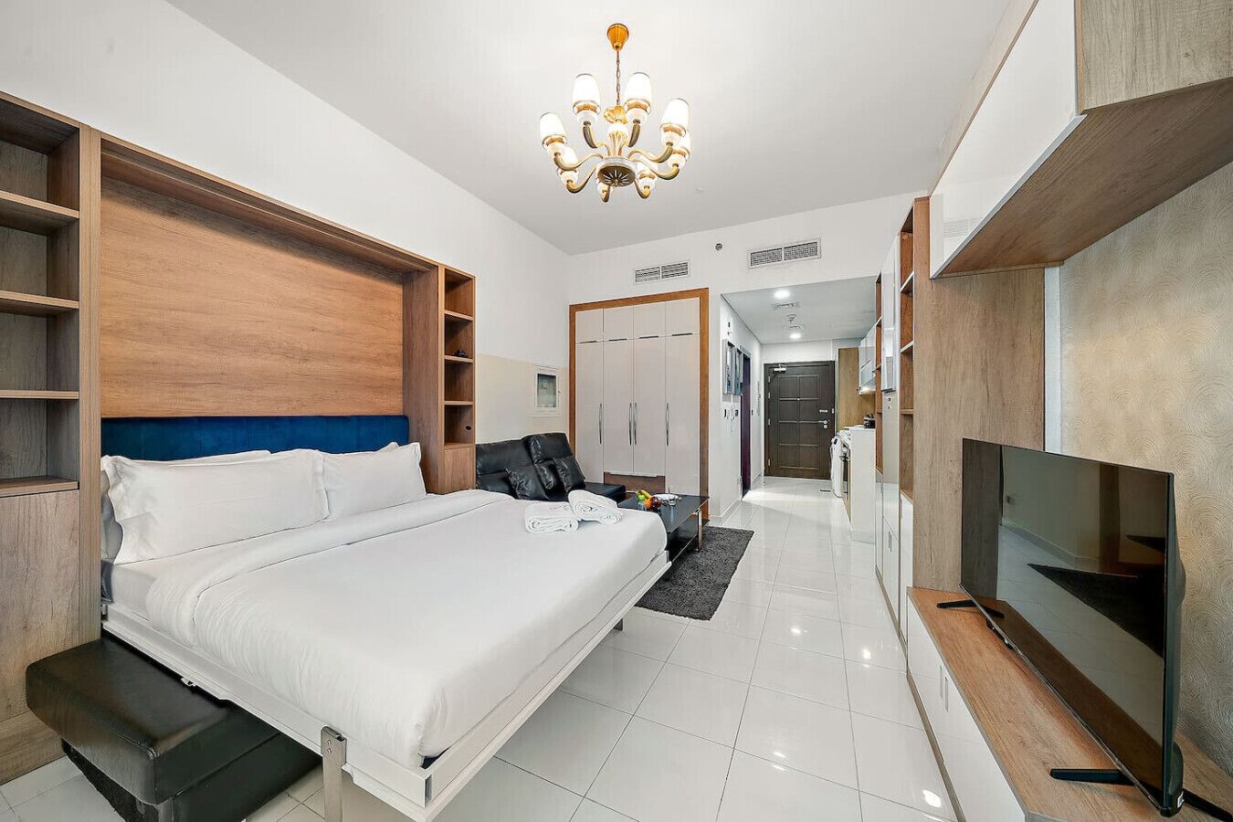Een moderne hotelkamer met een groot bed, een televisie, een bureau en een kledingkast.