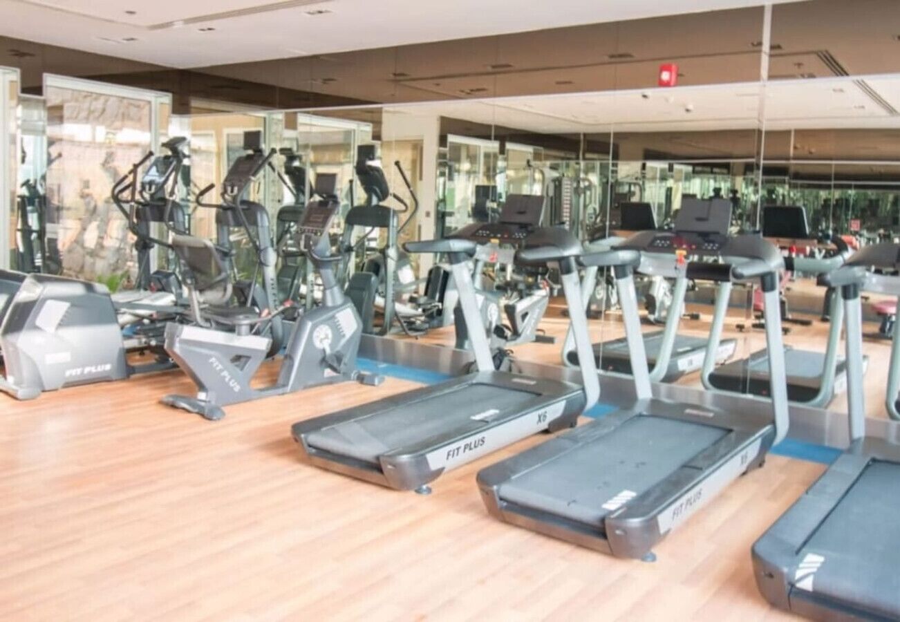 Et fitnesscenter med flere løbebånd og crosstrainere.