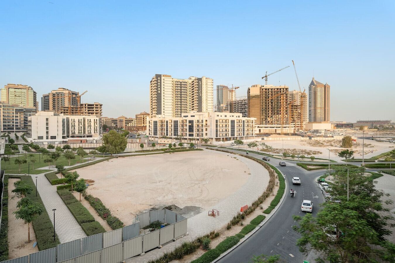 Un quartier urbain moderne caractérisé par de grands immeubles, un vaste espace ouvert et une route sinueuse.