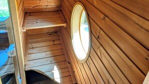 L’intérieur d’une cabane en bois, avec un escalier en colimaçon, une petite fenêtre et une porte.