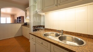 A kitchen with white cabinets, a granite countertop, and a double stainless steel sink.