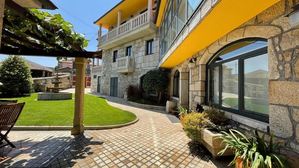 Un cortile con una fontana, un pergolato e un'area salotto.