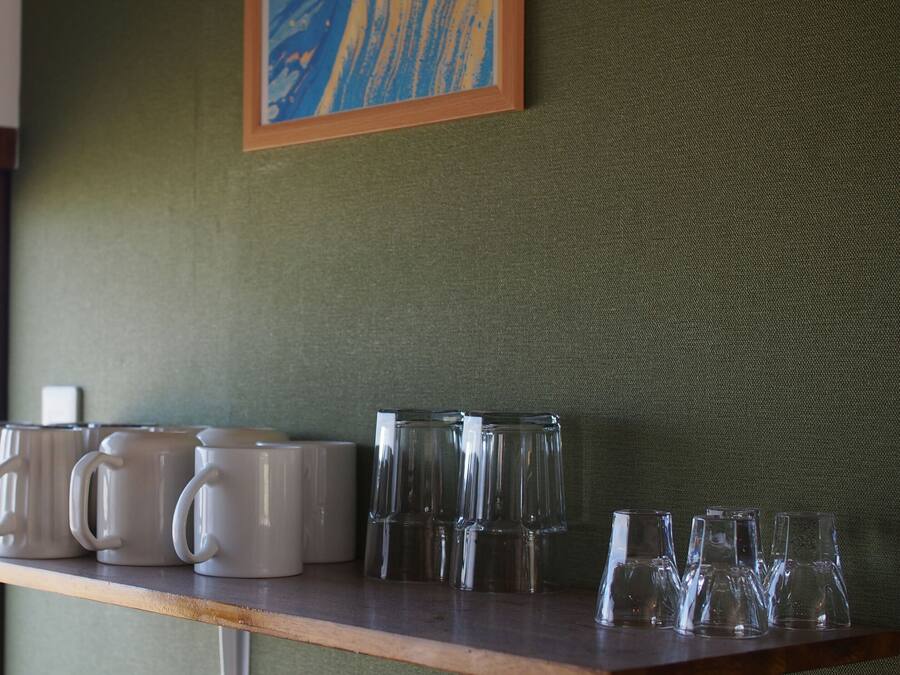 A shelf with various mugs and glasses.