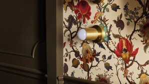A wall with a floral wallpaper and three wall-mounted light fixtures. - Designed for the solo traveller or couple looking for a taste of the Hotel Julie experience. (Stratford)