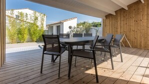 An outdoor patio with a wooden deck, a round table, and four chairs. - Family house for 10 with patio and pool in La Flotte (La Flotte)