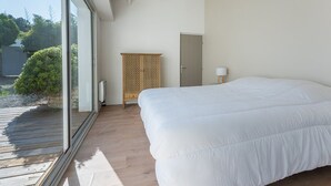 A bedroom with a large bed, a wooden wardrobe, a door, and a window overlooking a garden. - Family house for 10 with patio and pool in La Flotte (La Flotte)