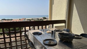 Ein Tisch für zwei auf dem Balkon mit freiem Blick auf das Meer und den Strand.