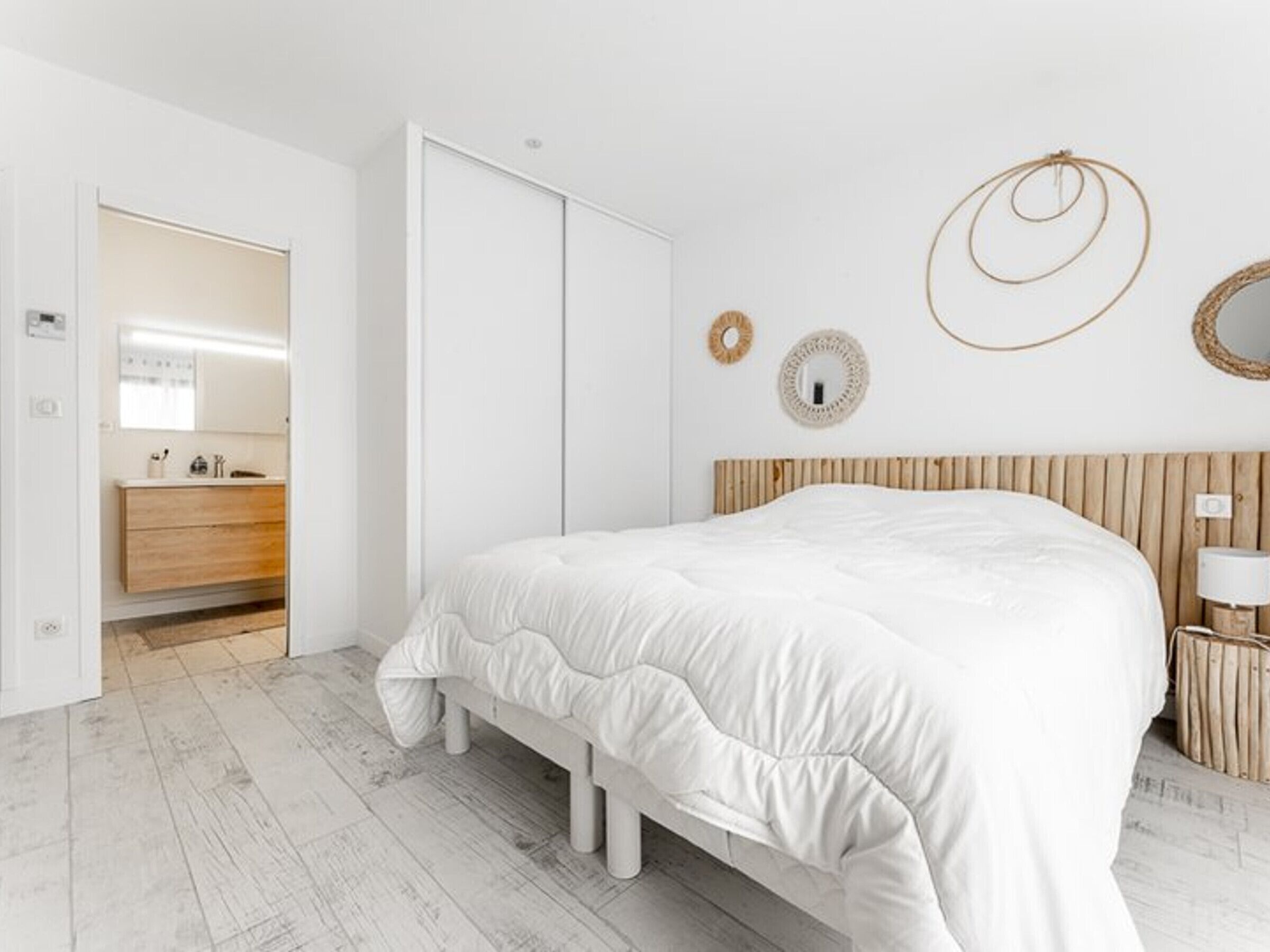 Une chambre à coucher avec un grand lit, une tête de lit en bois, une table de chevet et une armoire.