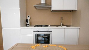 A kitchen with white cabinets, a gas stove, an oven, and a sink. - O03 – Osimo, One-Bedroom Apartment with Terrace and Wi-Fi (Osimo)