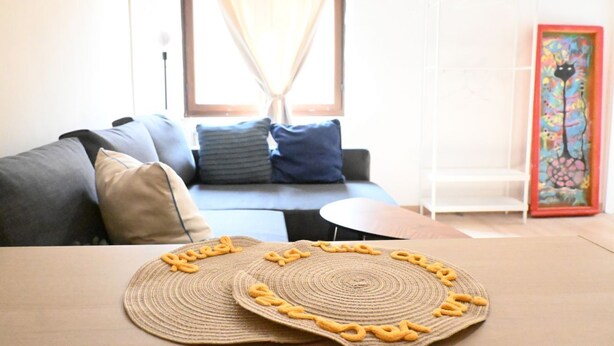 A living room with a sofa, a coffee table, and a decorative item on the wall. - O03 – Osimo, One-Bedroom Apartment with Terrace and Wi-Fi (Osimo)