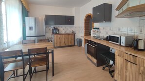 A compact kitchen with a wooden island, a microwave, a kettle, and a sink. - Ferien_Haus & Groß Grundstück in Bad Elster (Bad Elster)
