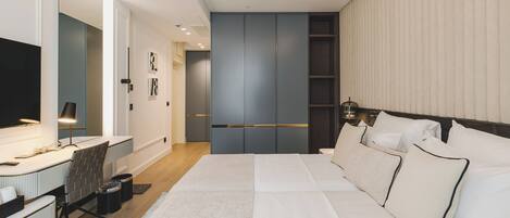 Una habitación de hotel moderna con una cama grande, un escritorio con una silla, un televisor de pantalla plana y un armario.