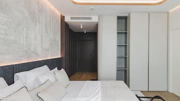 Un dormitorio moderno con una cama grande, un armario y un vestidor.