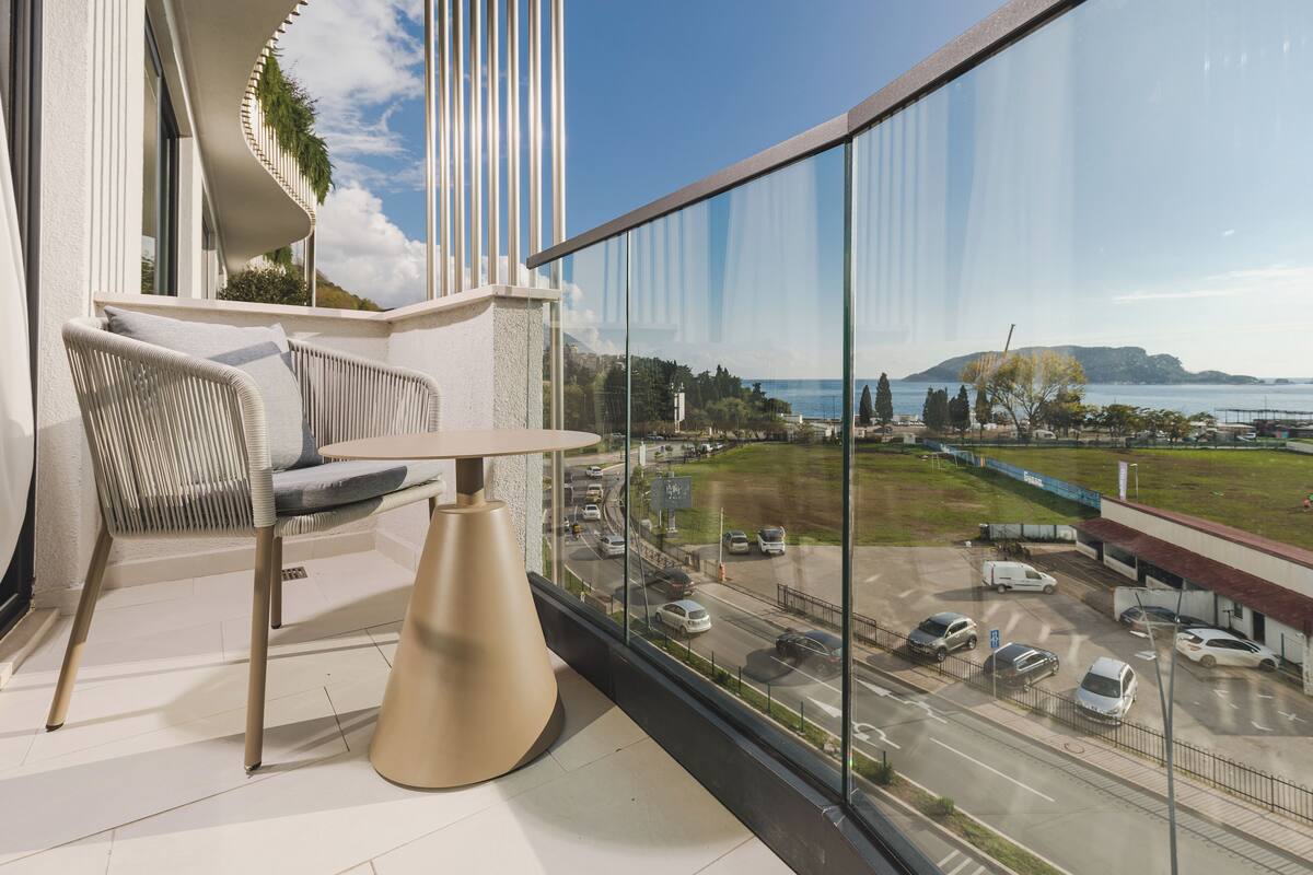 Un balcon donnant sur une route et un plan d’eau.