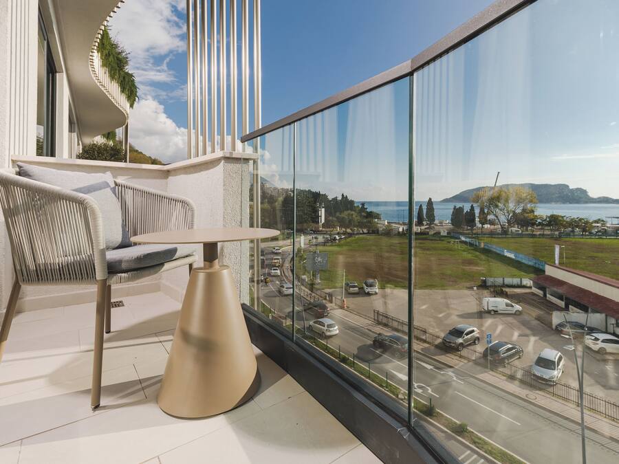 A balcony with a view of a road and a body of water.