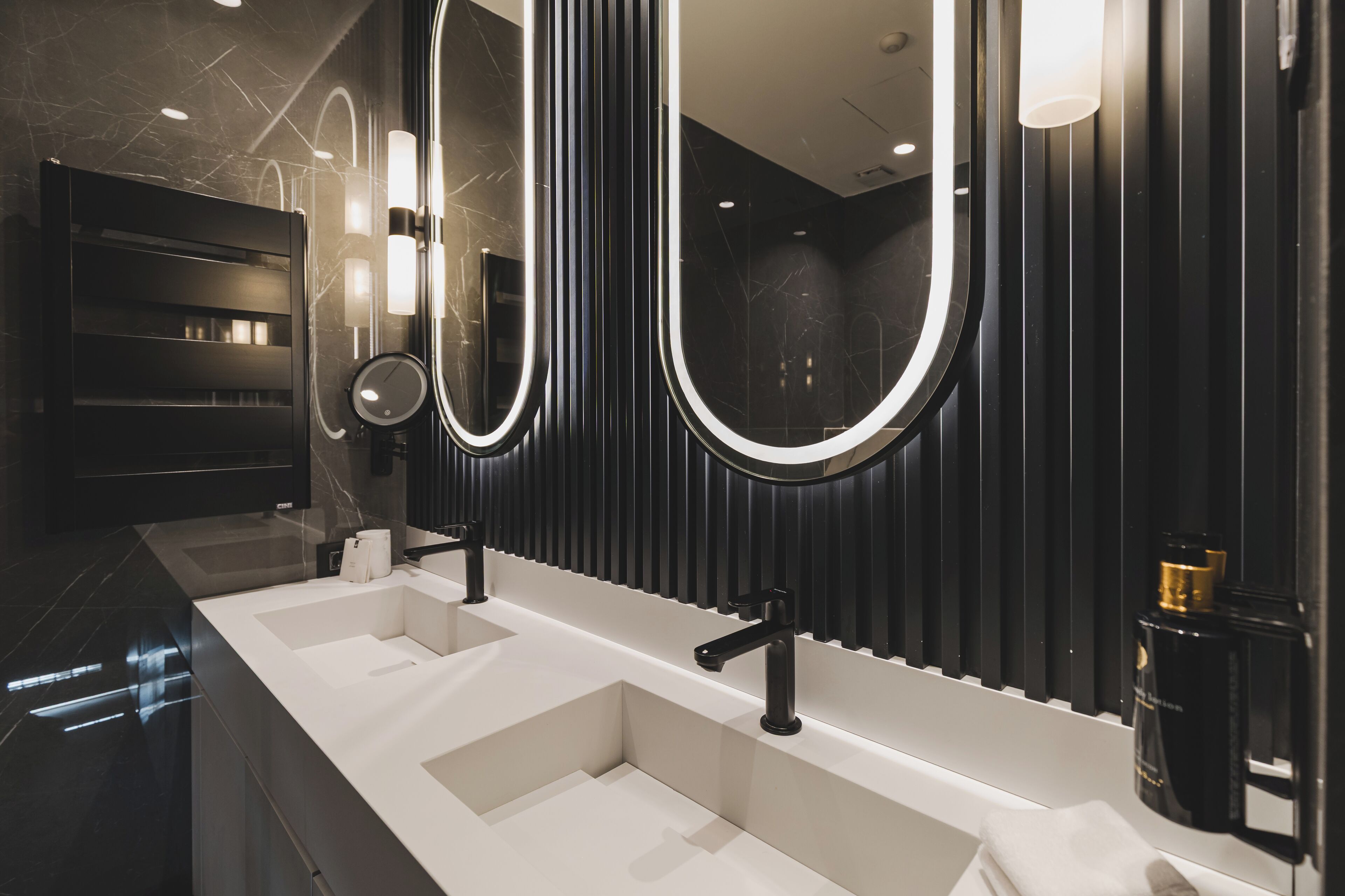 A modern bathroom with a long vanity, two sinks, and large mirrors.