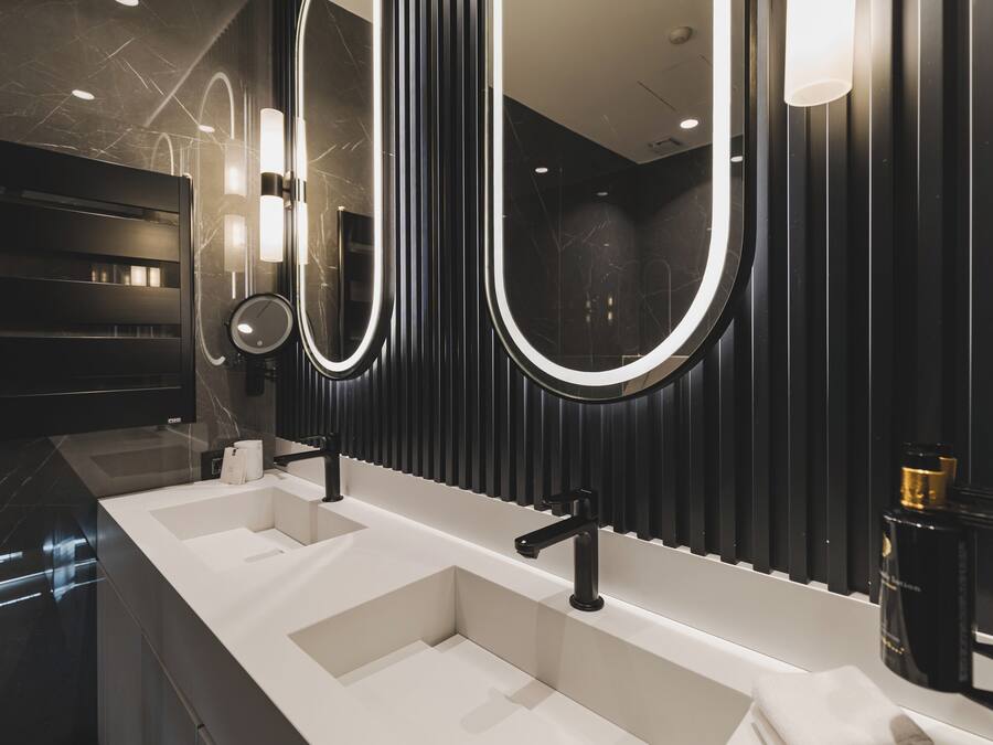 A modern bathroom with a long vanity, two sinks, and large mirrors.
