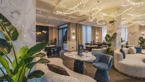 Eine moderne Hotelhalle mit Marmorsäulen, bequemen Sitzgelegenheiten und stimmungsvoller Beleuchtung.